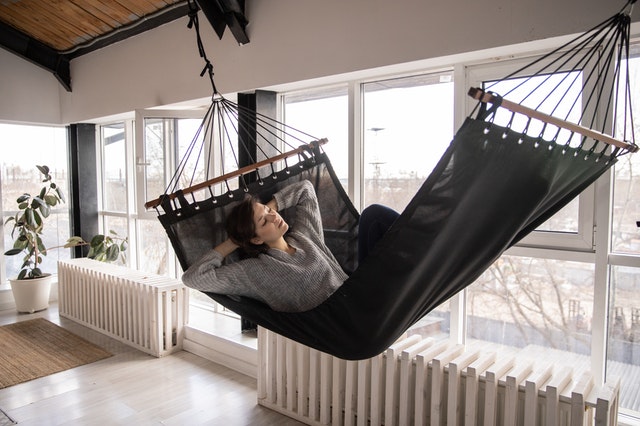 A woman in a hammock in a warm room